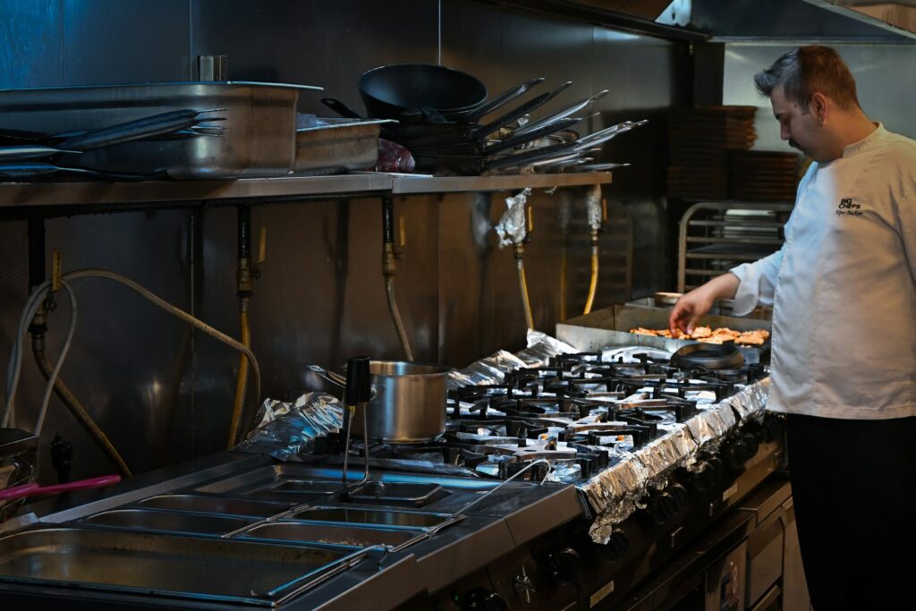 Chef cooking in a commercial kitchen, where grease and hot equipment create fire risk