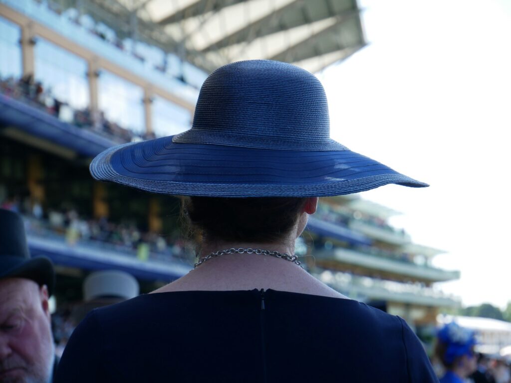 Woman in a blue hat at Royal Ascot, dressed for race day